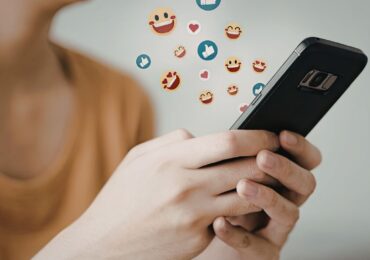 A wellness studio owner, using social media on her phone.