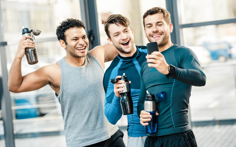 gym rewards program, three happy friends looking at phone