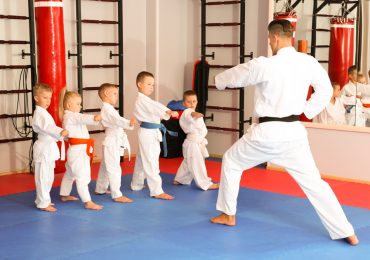 teaching children martial arts, karate instructor training little children in dojo