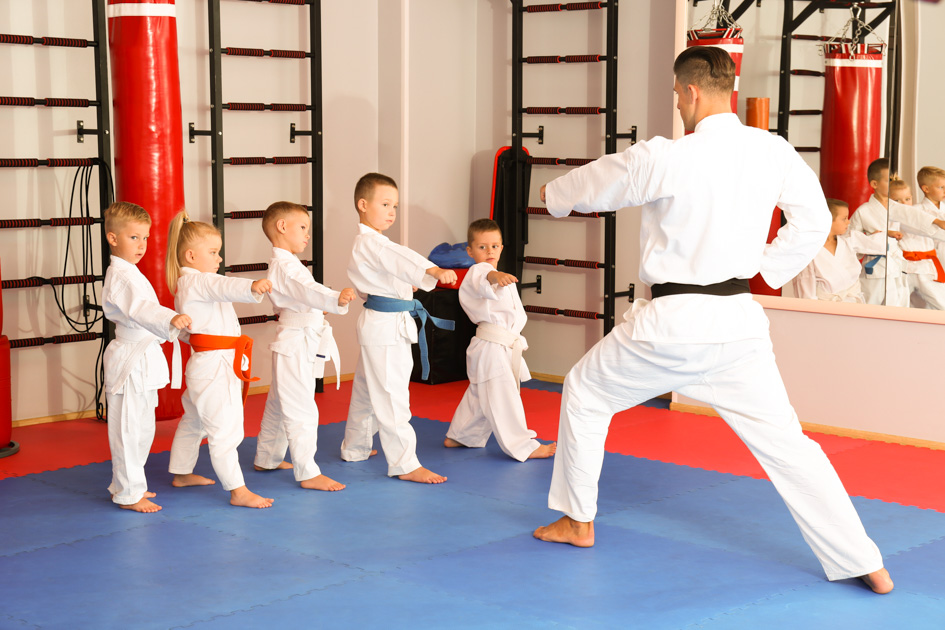 teaching children martial arts, karate instructor training little children in dojo