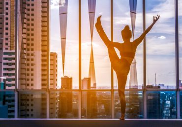 yoga studio marketing ideas, Woman practicing yoga on city view