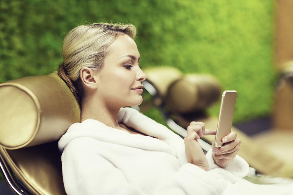 wellness center apps, woman at spa on phone