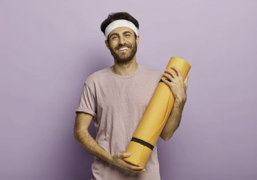 yoga studio merchandise, happy man holding yoga mat