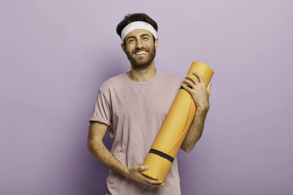 yoga studio merchandise, happy man holding yoga mat