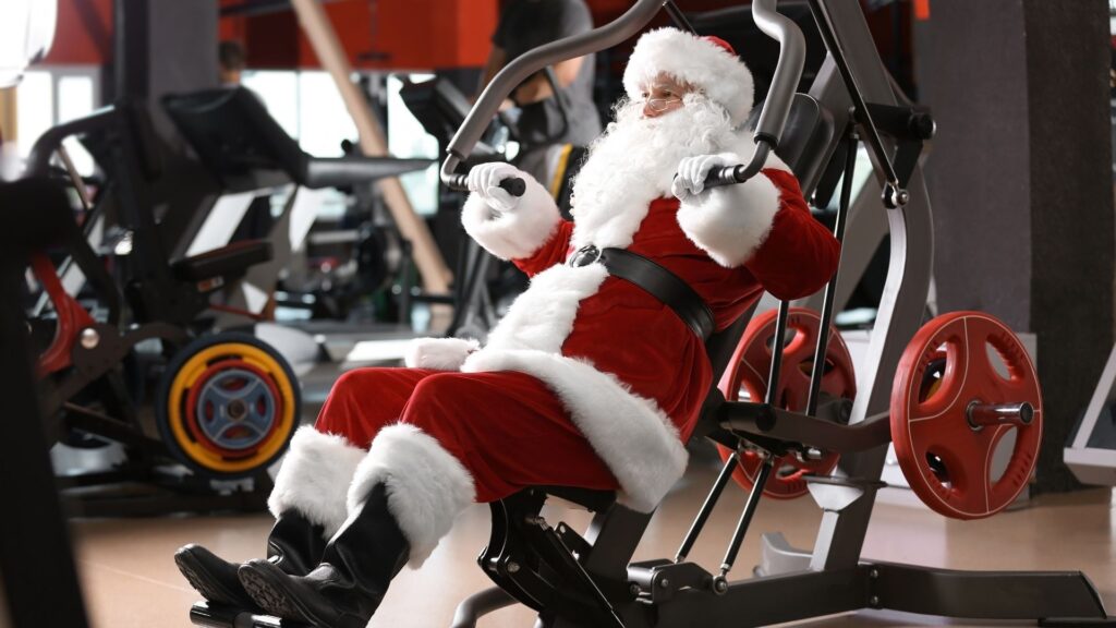 Santa working hard on a bench press machine, staying motivated in his holiday workout routine.