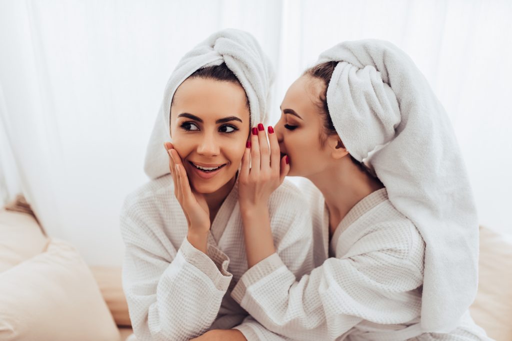 upselling techniques, two women whispering in spa