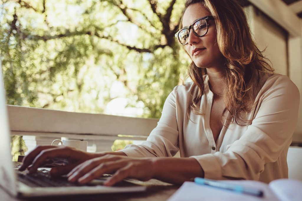 business management softwares, businesswoman at cafe working on laptop