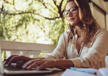 business management softwares, businesswoman at cafe working on laptop