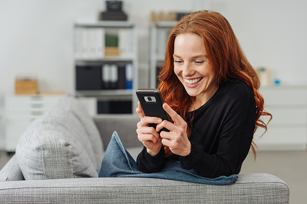 franchise cloud, young cheerful woman using mobile phone on sofa