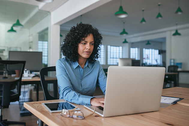 online services, focused young businesswoman using a laptop at her office desk