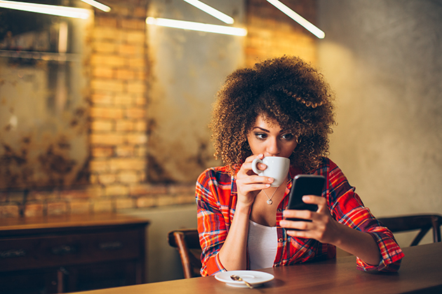 wellness center, young woman at cafe drinking coffee and using mobile phone