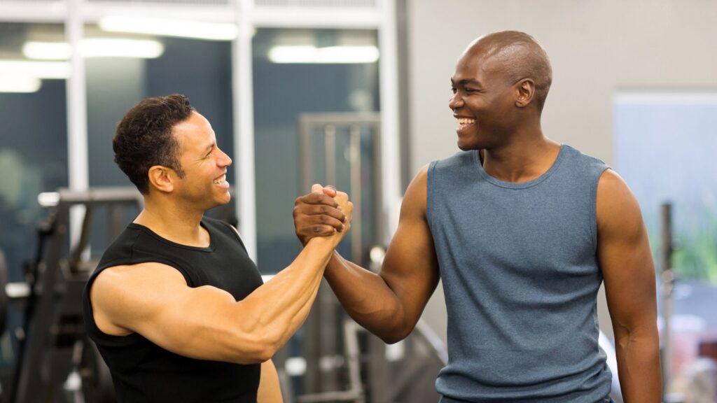 A new gym member being congratulated after a free intro offer weightlifting class.