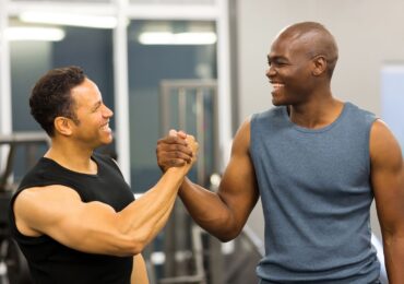 A new gym member being congratulated after a free intro offer weightlifting class.