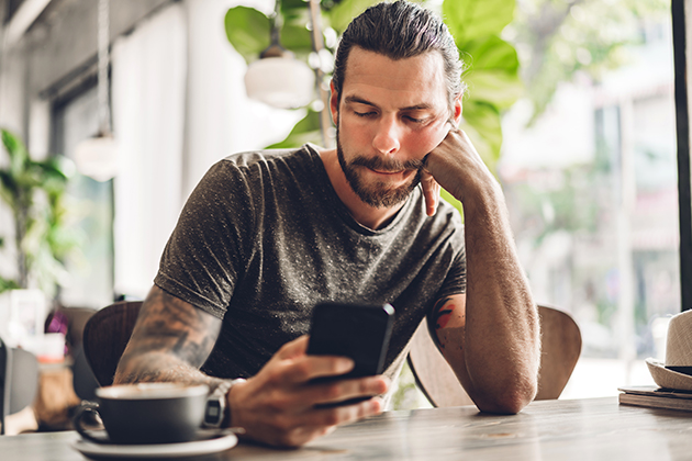 celebrate your staff, handsome bearded hipster man use smartphone with coffee at table