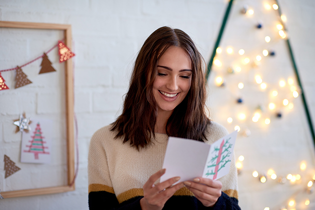 celebrate your staff, woman smiling while reading handmade card greeting