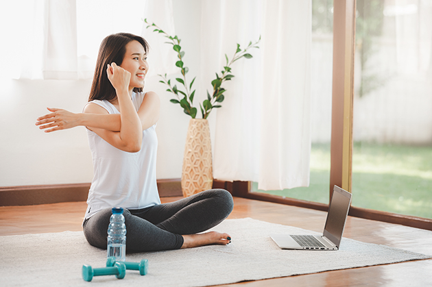 intro offers, Asian woman doing yoga shoulder stretching online class at home