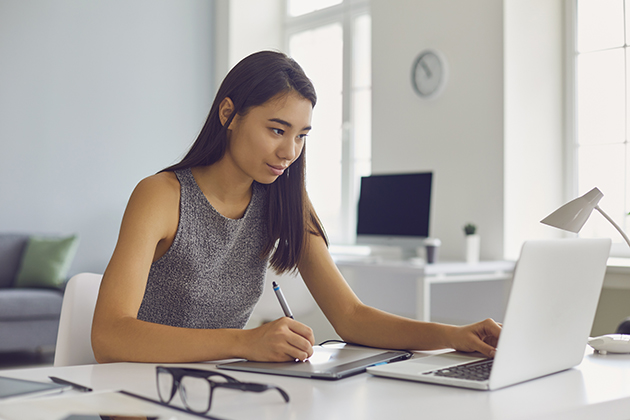 New Year's resolution, young woman working on graphic design project using modern tablet and laptop computer