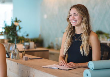 Receptionist at wellness studio greets client