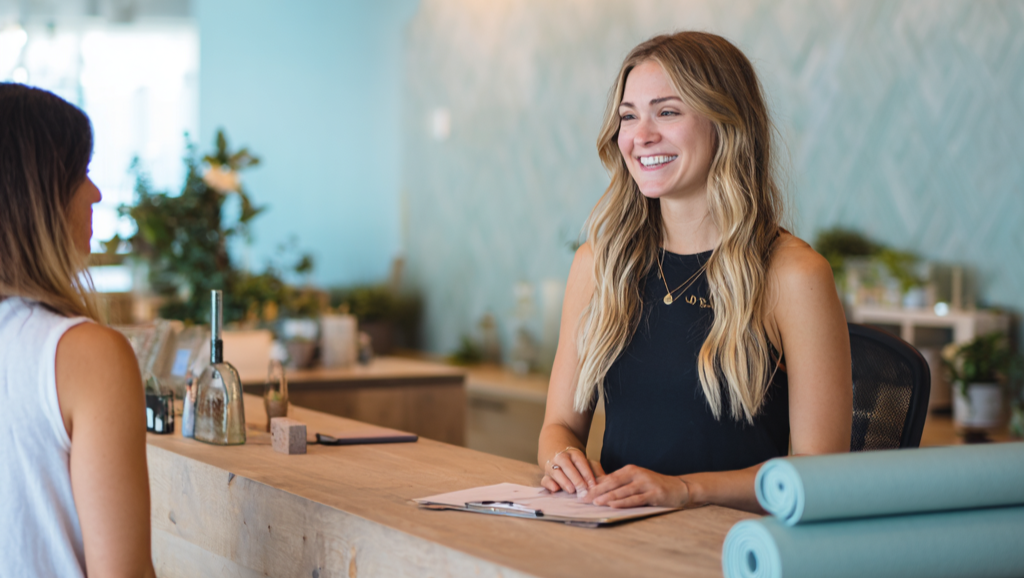 Receptionist at wellness studio greets client