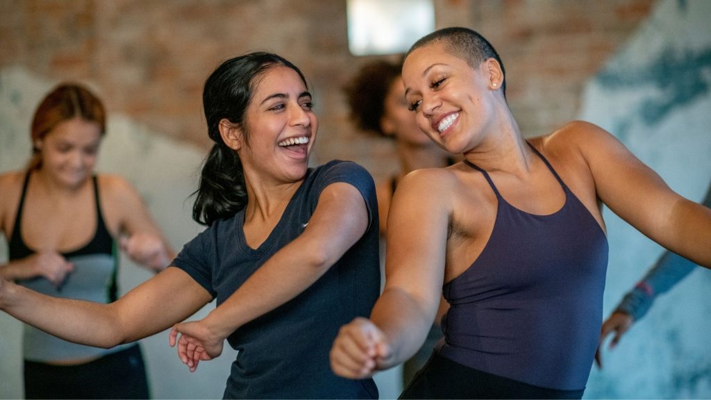 Two friends enjoying a dance class together after getting their schedules to line up.