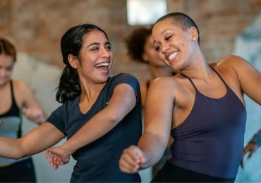 Two friends enjoying a dance class together after getting their schedules to line up.