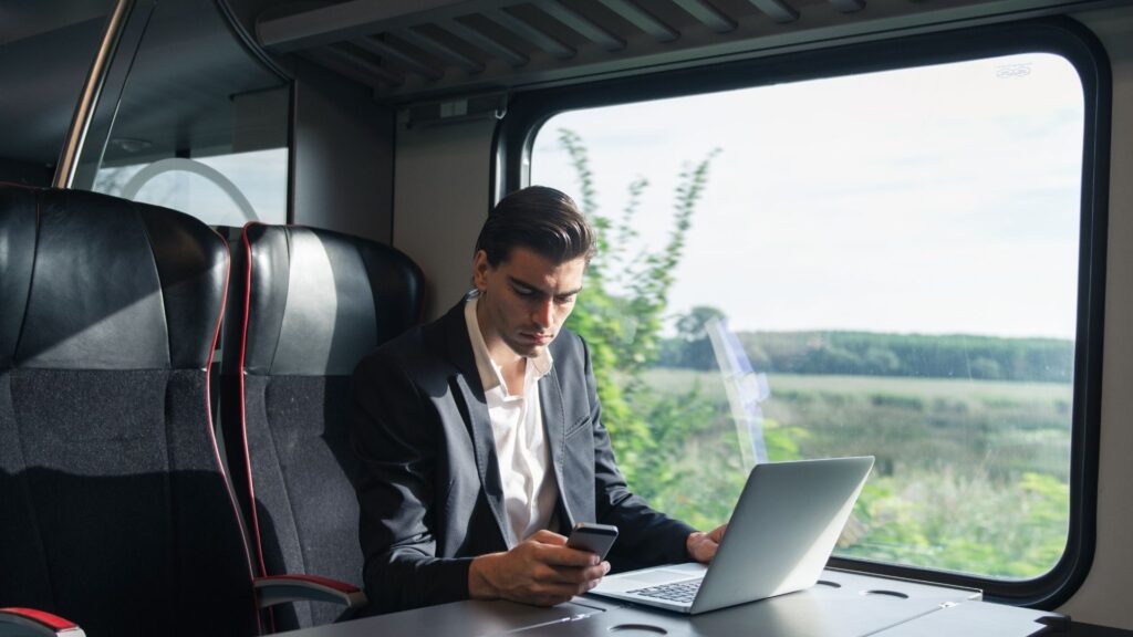 A small business owner checks his email and messages while on a train.