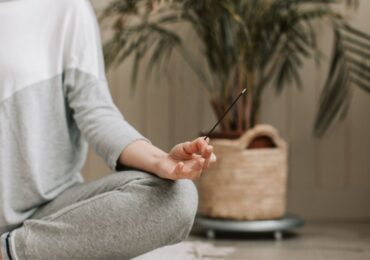 A wellness studio owner meditating in her studio run by WellnessLiving.