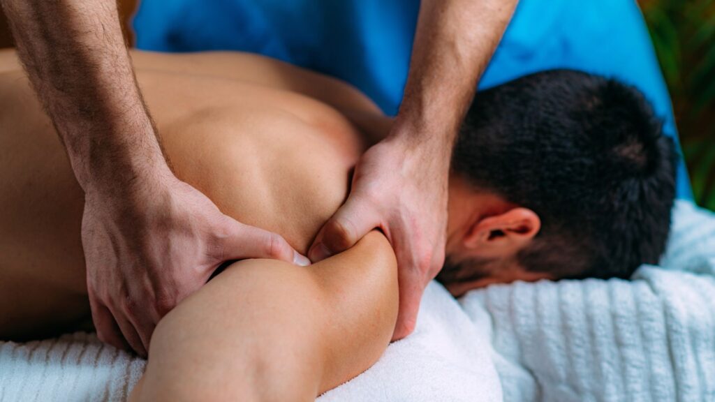 A massage therapist working on his client's shoulder.