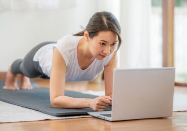 A young woman in the middle of her online fitness class.
