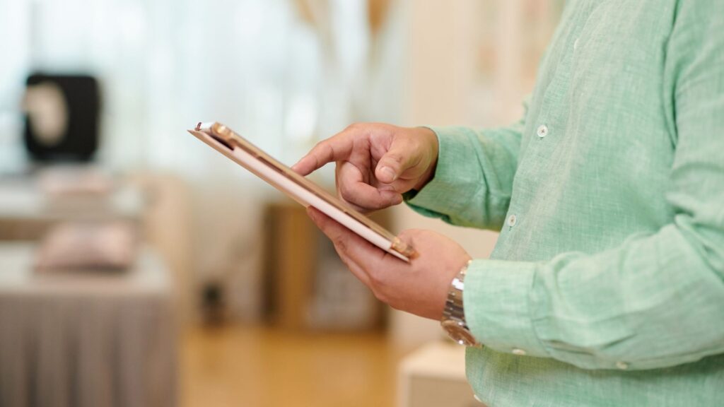 The owner of a wellness studio, managing client profiles on his tablet.