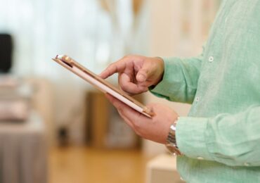 The owner of a wellness studio, managing client profiles on his tablet.