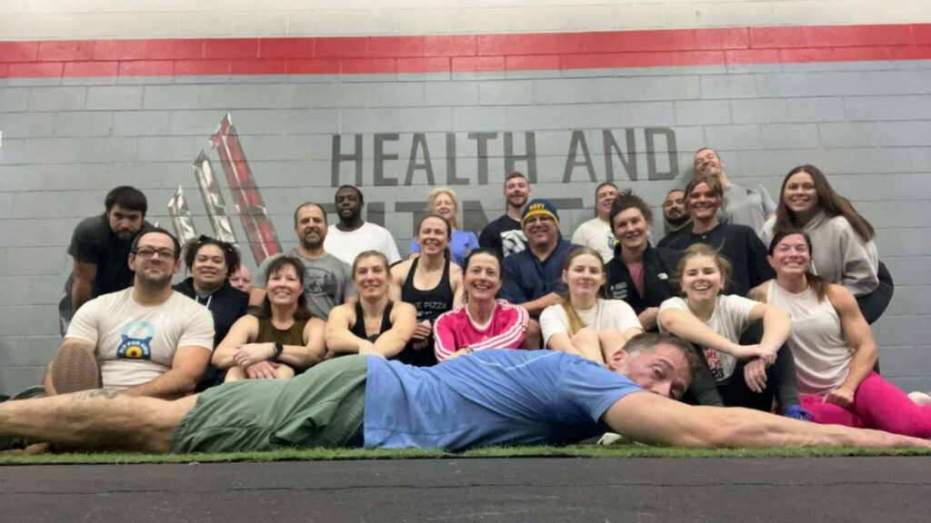 A group picture at A1 Health and Fitness with Alex, the owner, planking in front.