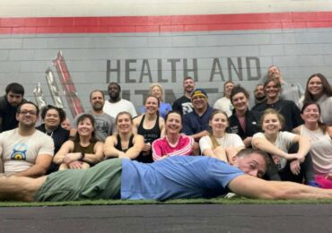 A group picture at A1 Health and Fitness with Alex, the owner, planking in front.