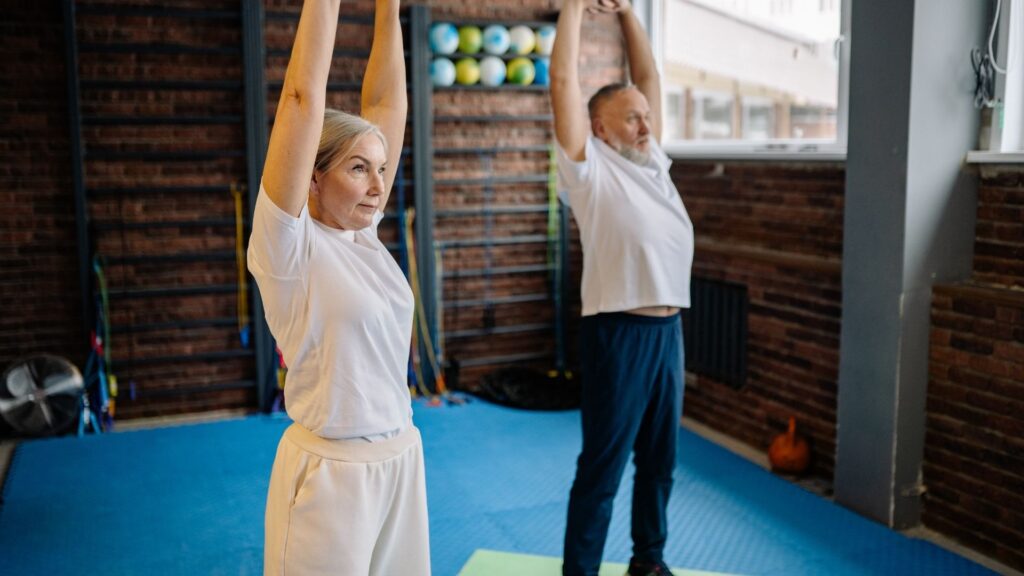 Two people in a stretching class at Achieve Therapy and Fitness.