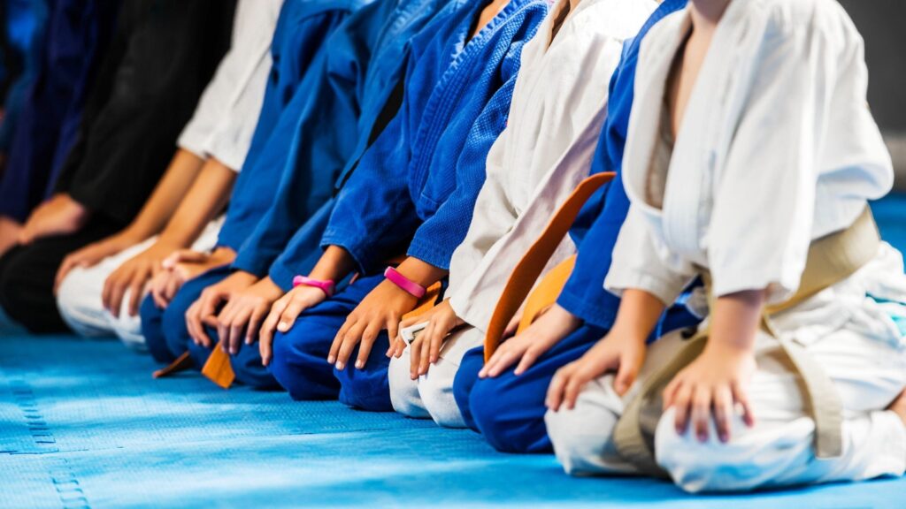 Students at the D'Souza Martial Arts Academy, kneeling on the mat before a class.