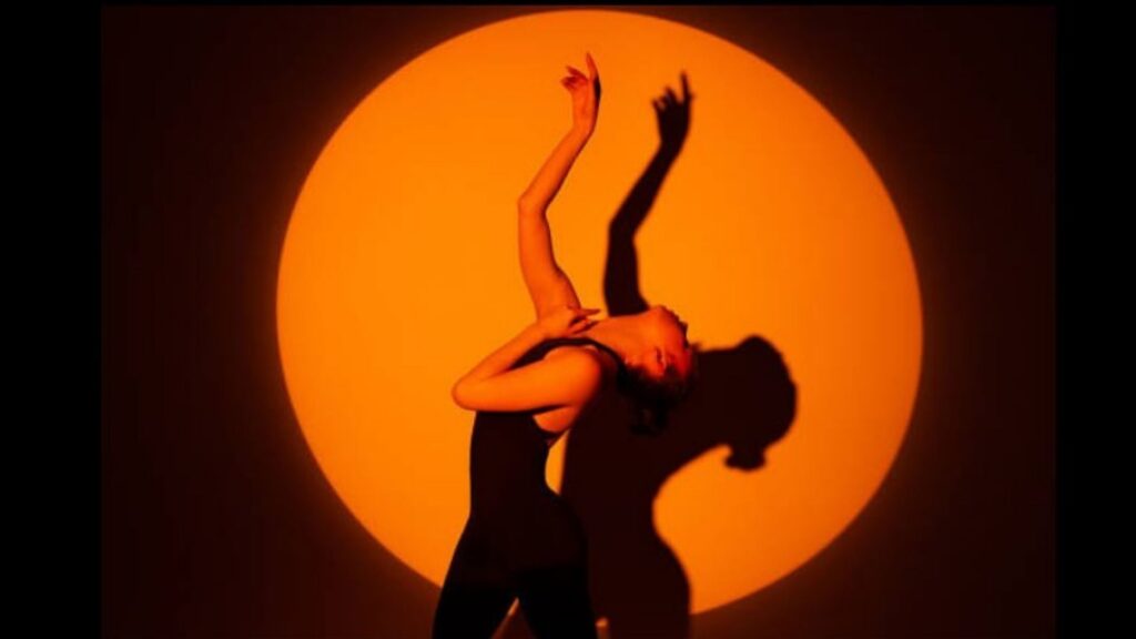 A dancer at Kinesi Dance Complex, posing in the spotlight.