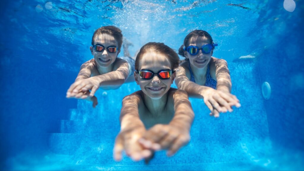 A group of kids at Megan’s Mobile Swim School, swimming under water confidently.