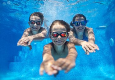 A group of kids at Megan’s Mobile Swim School, swimming under water confidently.