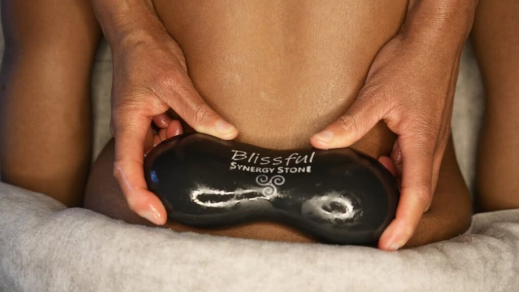 Someone receiving an energy stone massage from Praying Hands Massage and Bodywork.