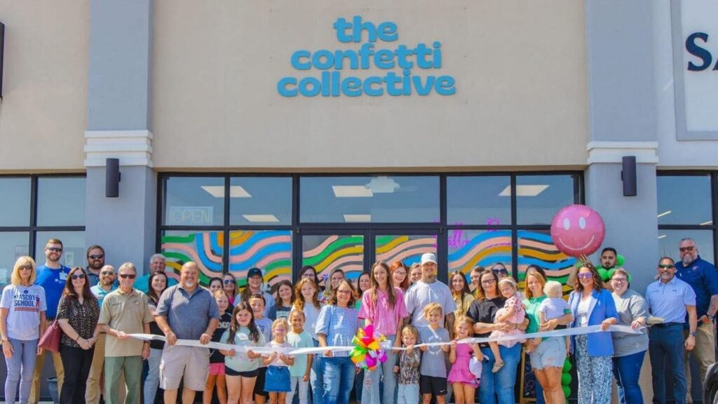 A large group of people gathering in front of The Confetti Collective at their grand opening.