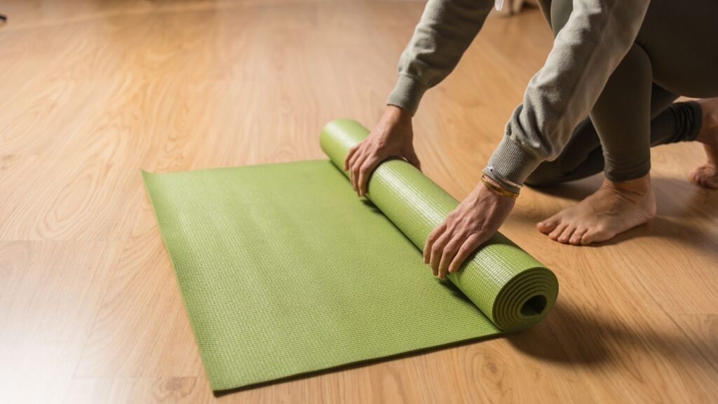 A yoga studio owner rolling up a clean yoga mat after class.