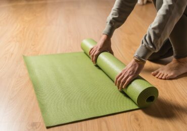 A yoga studio owner rolling up a clean yoga mat after class.