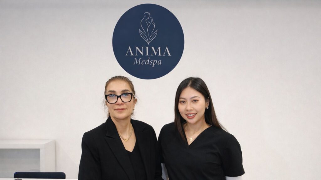 The owners of Anima Medspa posing at the front desk.