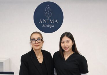 The owners of Anima Medspa posing at the front desk.