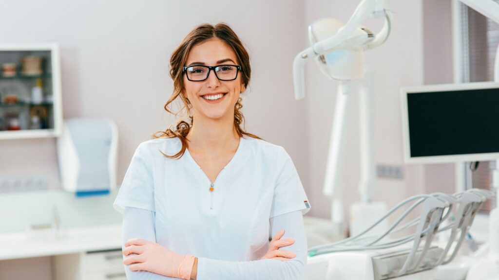 The owner of a dental practice, stands proudly in front of her new equipment.