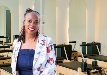 The owner of Pilates 4 Me, posing in front of her equipment.