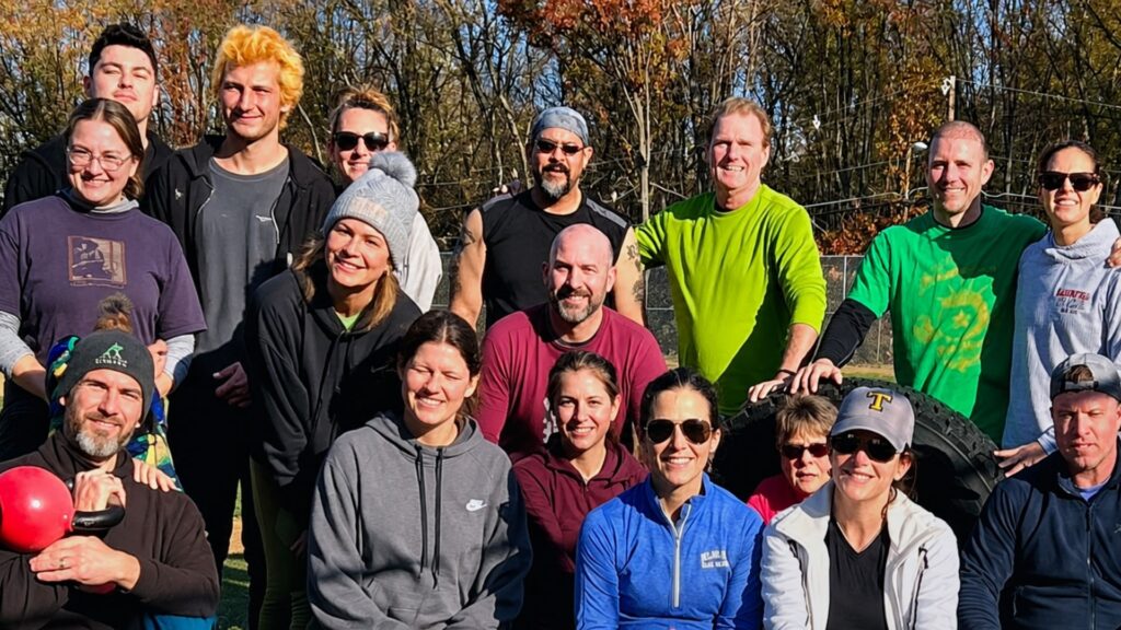 A group of trainees in an outdoor group photo with Evolution Fitness Now.