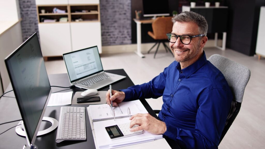 A small business owner, doing his accounting at his desk.