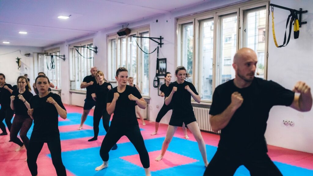 A popular kick boxing class, moving through their forms together.