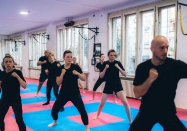 A popular kick boxing class, moving through their forms together.